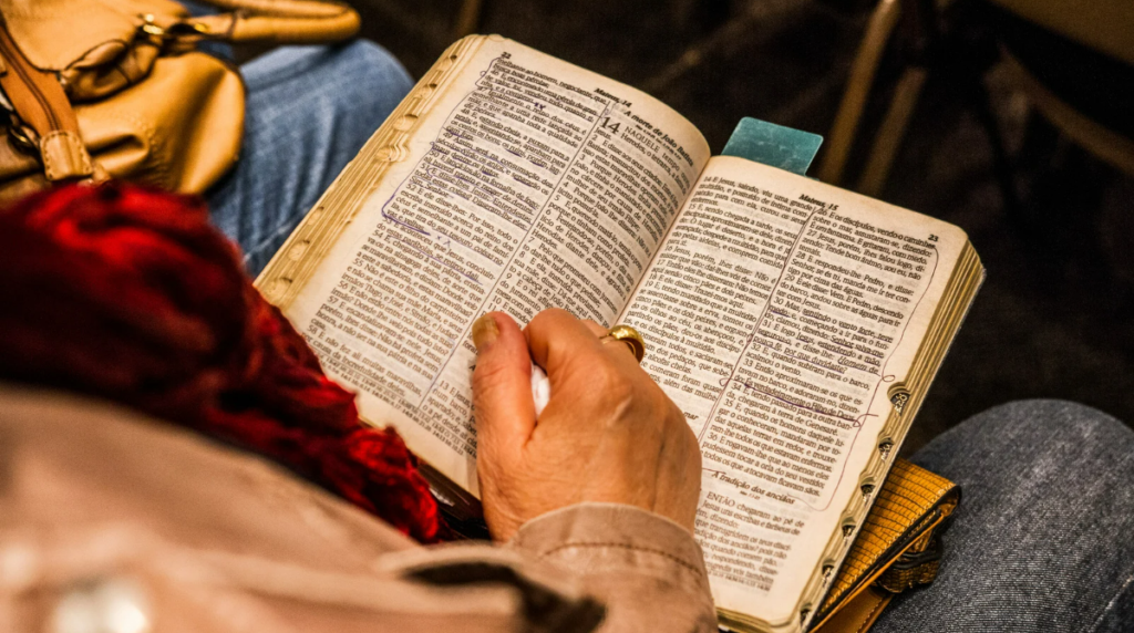 elderly person reading marked up bible
